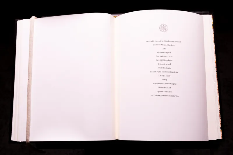 Open pages of a book with the names of the inductees to the Chancellor's Circle 2024 including Cystinosis Ireland.